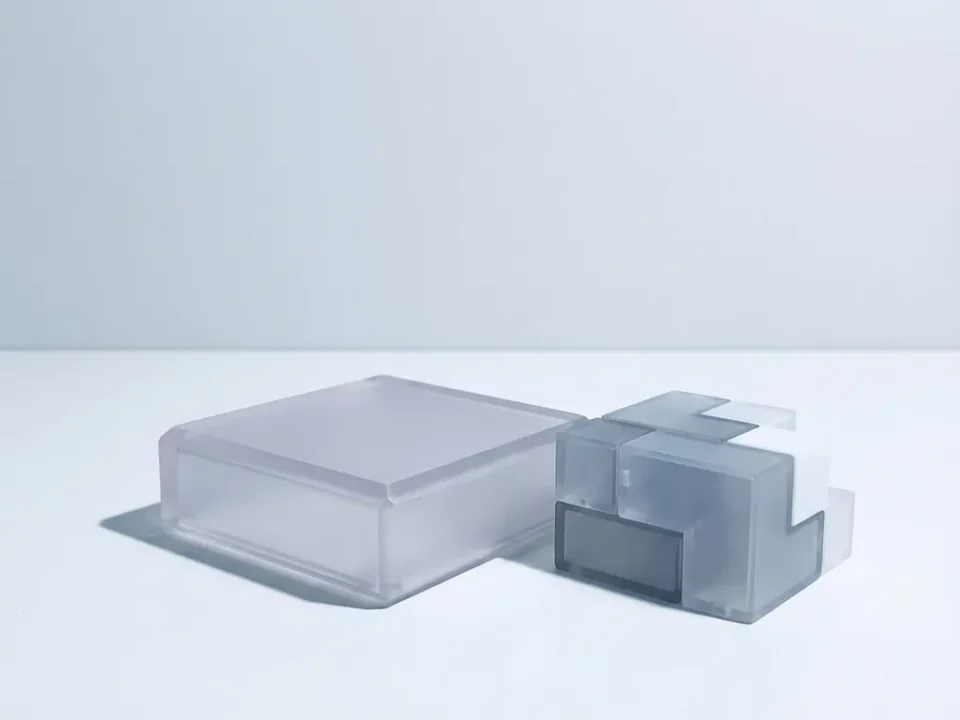 Modulaire frosted acryl bouwblokken in minimalistisch design op wit oppervlak, zacht licht benadrukt geometrische vormen.